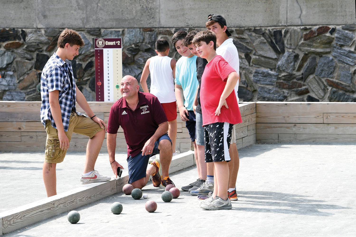 Lou Tobacco, president of Msgr. Farrell High School and camp director, checks the bocce balls during a match.