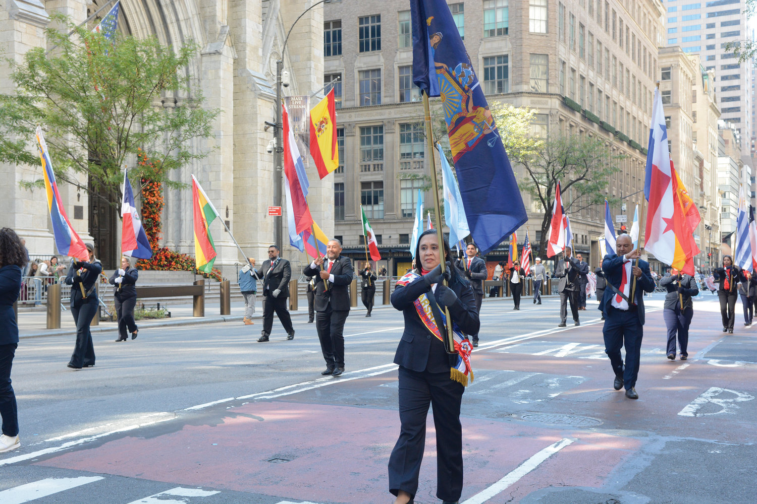 HERENCIA HISPANA—Foto, banderas latinoamericanas abundan mientras participantes pasan la Catedral de San Patricio durante el desfile anual del Día de la Hispanidad NYC el 9 de octubre en la Quinta Avenida.