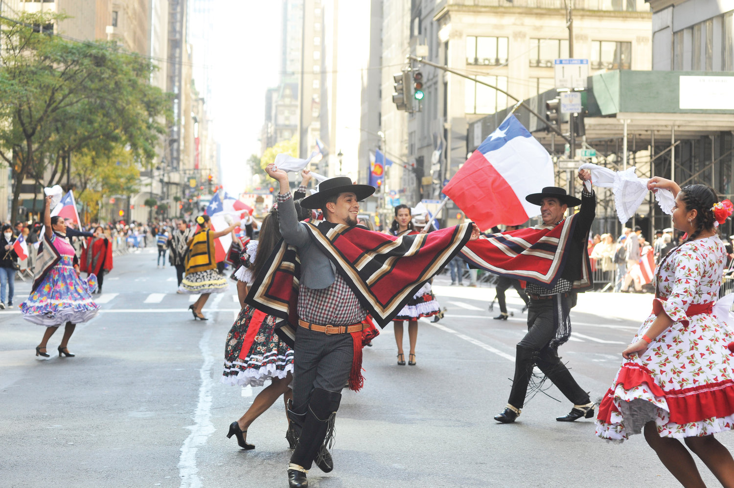 EVENTO FESTIVO—Participantes vestidos de muchos colores marchan en la Quinta Avenida en Manhattan el 9 de octubre durante el desfile anual del Día de la Hispanidad NYC.