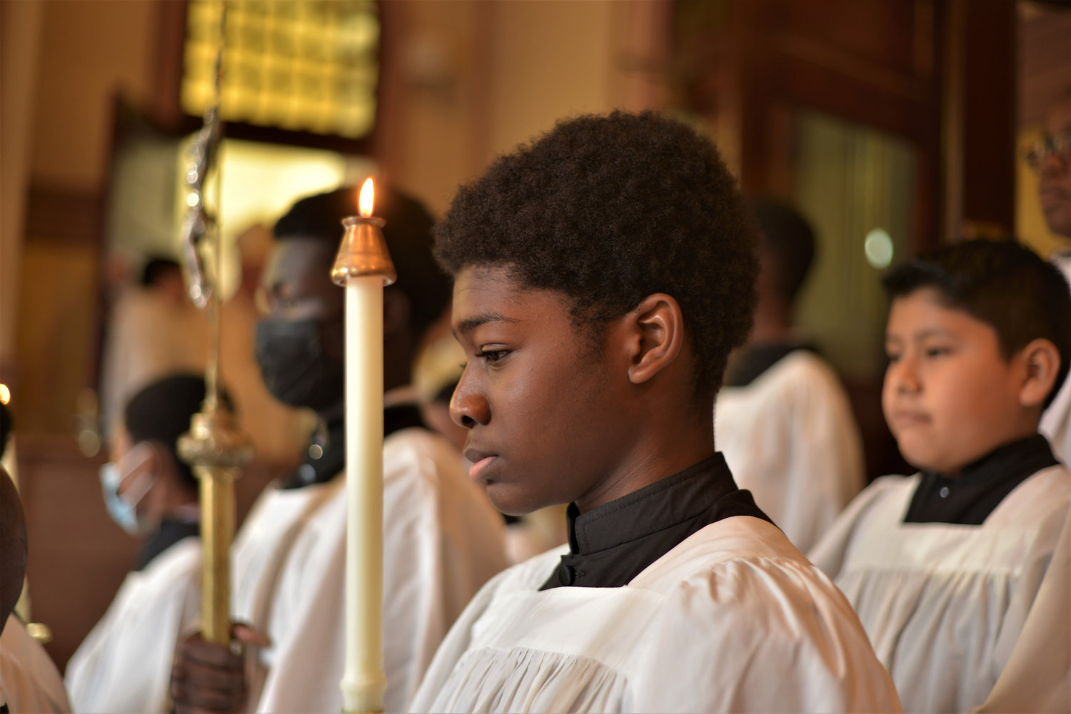 Altar server Michael Oppong holds a candle during the Oct. 22 Mass commemorating the 125th anniversary of St. Luke’s parish in the Bronx. Cardinal Dolan served as the principal celebrant and homilist. “You know today is the feast of Pope St. John Paul II,” the cardinal said. “And Pope St. John Paul II once called the parish ‘the family of families,’ and that’s so true here at St. Luke’s.”