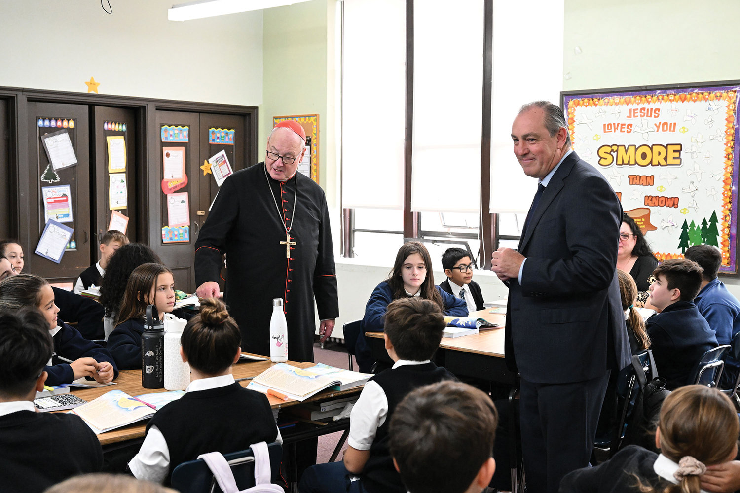 ASSISTING CATHOLIC SCHOOLS—Cardinal Dolan and Staten Island Borough President Vito J. Fossella visit a classroom at Blessed Sacrament School on Staten Island Oct. 24 after Fossella announced $457,300 in funding to sports and arts programs for all students at 21 Catholic schools in the borough.